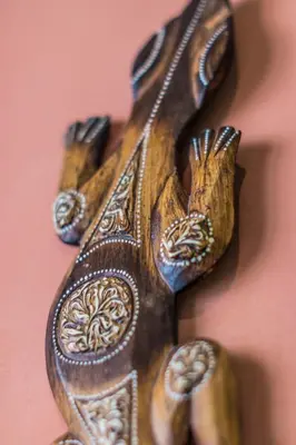 a wooden object with four hands on a wall at Gaia Hydro-Spa and Guest House in Cape Town