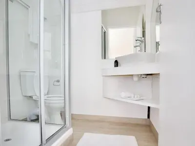 a bathroom with a shower and a toilet and a sink at Cosimi Guest House in Durbanville