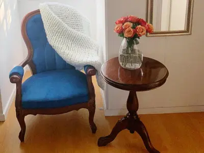 a blue chair and a table with a vase of flowers at Cosimi Guest House in Durbanville
