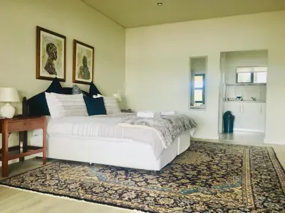 a bedroom with a large white bed and a rug at Witzenberg Guest Farm in Wolseley