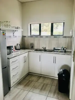 a kitchen with white cabinets and a sink at Witzenberg Guest Farm in Wolseley
