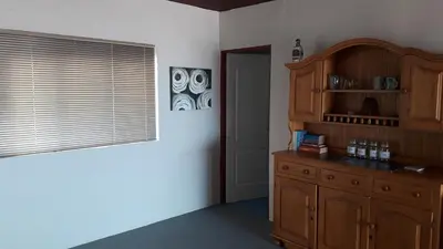 a room with a wooden cabinet and a window at Jack's Seaview in Bettyʼs Bay