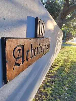a sign on a wall that says albuquerque at Arbeidsgenot Beach House in Hermanus