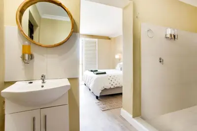 a bathroom with a sink and a mirror and a bed at Lord's Wine Farm in McGregor