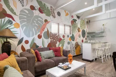 a living room with a couch and a colorful wall at The Potting Shed Guest House in Hermanus