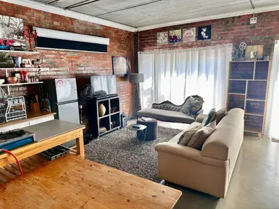 a living room with a couch and a brick wall at the STUDIO apartment in Durbanville in Durbanville