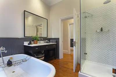 a bathroom with a tub and a sink and a mirror at Stellenbosch Manor in Stellenbosch