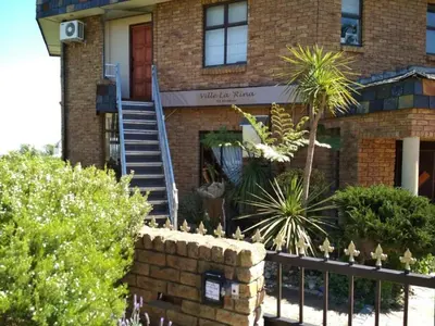 a brick house with a staircase in front of it at Ville la'Rina in Cape Town