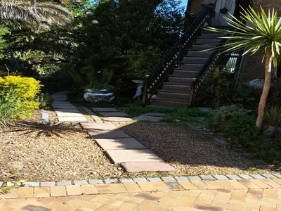 a garden with a stone walkway next to a staircase at Ville la'Rina in Cape Town