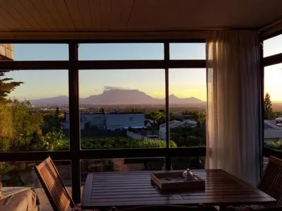 a room with a large window looking out at the mountains at Ville la'Rina in Cape Town