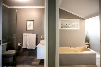 a bathroom with a tub and a sink at Son & Saffier in Hermanus