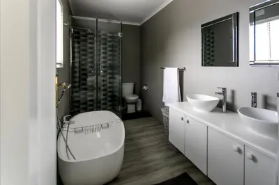 a bathroom with two sinks and a tub and a shower at Son & Saffier in Hermanus