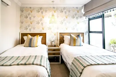 two beds in a bedroom with a window at Serendipity in Hermanus