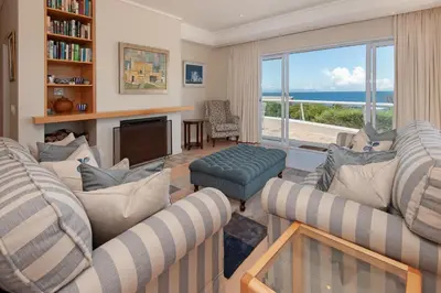 a living room with two couches and a view of the ocean at Bietou on the Sea in Hermanus