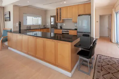 a kitchen with a large island with a black counter top at Bietou on the Sea in Hermanus