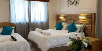 a bedroom with two beds with blue and white pillows at Lodge Strand (The) in Strand