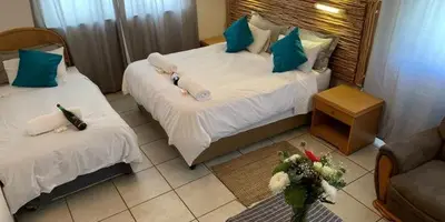a hotel room with two beds and a couch at Lodge Strand (The) in Strand