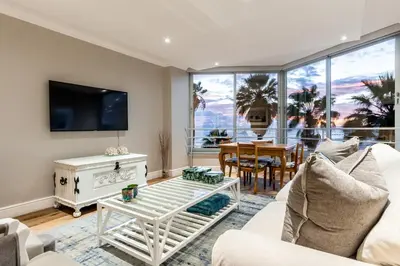 a living room with a white couch and a table at Ashley on Beach Strand in Strand