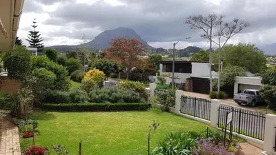 a view of a yard with a garden with mountains in the background at Brookshill - Protea suite in Somerset West
