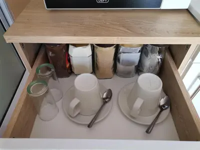 a cabinet with two plates and cups and utensils at Onyx on Sycamore in Cape Town