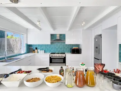 a white kitchen with bowls of food on a counter at Salt Boutique Guest House in Bloubergstrand
