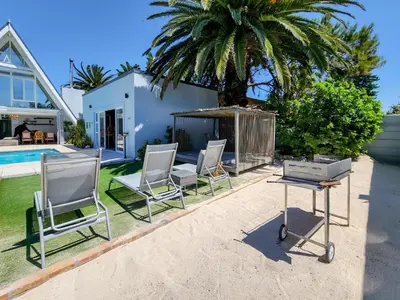 a group of chairs and a table in front of a house at Salt Boutique Guest House in Bloubergstrand