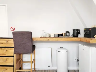 a kitchen with a counter with a chair on it at Salt Boutique Guest House in Bloubergstrand