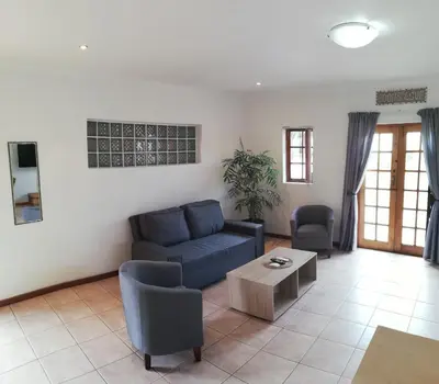 a living room with a blue couch and a table at Coons Cove in Cape Town