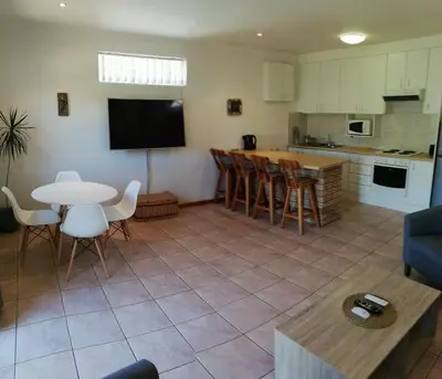 a kitchen and a living room with a table and chairs at Coons Cove in Cape Town