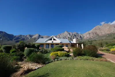 a house with mountains in the background at Kingsbury Cottage in Breerivier
