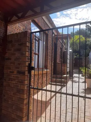 an iron gate on a brick building with a patio at On Yonder Hill in Cape Town