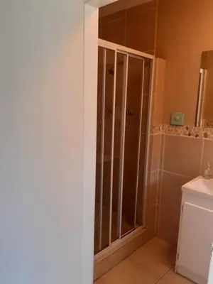 a bathroom with a shower with a glass door at On Yonder Hill in Cape Town