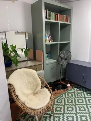 a room with a chair and a desk and a fan at Just a Bed parking on street in Stellenbosch