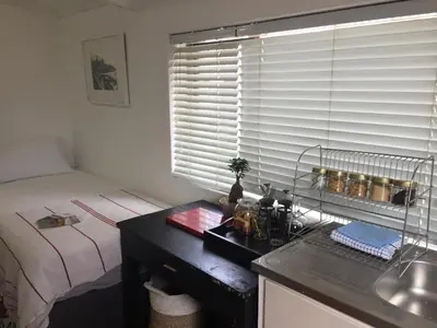 a bedroom with a bed and a desk and a window at Just a Bed parking on street in Stellenbosch