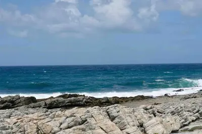 a rocky beach with the ocean in the background at Whales & Waves in Hermanus