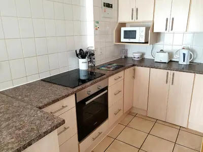 a small kitchen with a stove and a microwave at D'urban Ridge Self catering Apartment in Cape Town
