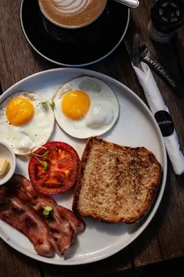 a plate of breakfast food with eggs bacon and toast at Skinkikofi Guest House in Paarl