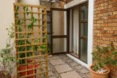 a wooden trellis is next to a door at @Abelia Guest House in Somerset West
