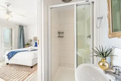a bathroom with a shower and a tub and a sink at Marechale Way in Cape Town