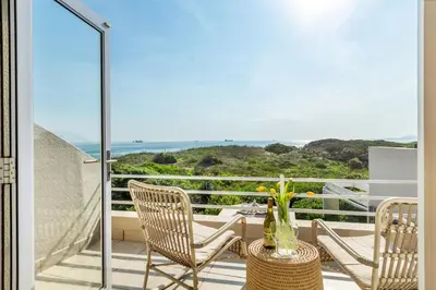 a balcony with chairs and a vase of flowers at Marechale Way in Cape Town