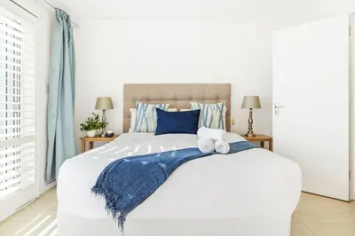 a bedroom with a large bed with two towels on it at Marechale Way in Cape Town
