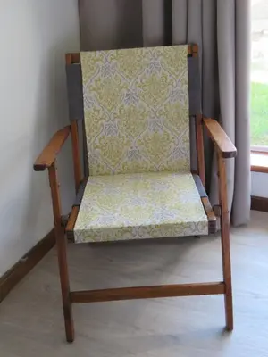 a wooden chair sitting in a room next to a window at Koraalboom Guesthouse in Wolseley