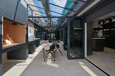 a room with a table and chairs in a building at Crown Comfort - Affordable luxury - Private Heated Pool & Hot Tub Under Roof in Cape Town