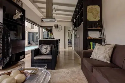 a living room with a couch and a table at Crown Comfort - Affordable luxury - Private Heated Pool & Hot Tub Under Roof in Cape Town