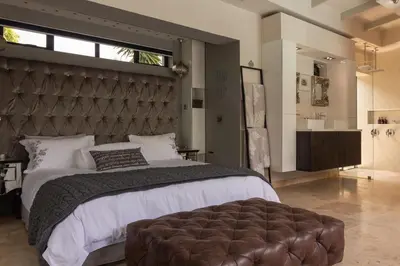 a bedroom with a large bed and a large window at Crown Comfort - Affordable luxury - Private Heated Pool & Hot Tub Under Roof in Cape Town