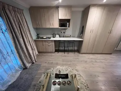 a kitchen with a table in the middle of a room at Ridgeworth, Tygervalley in Cape Town