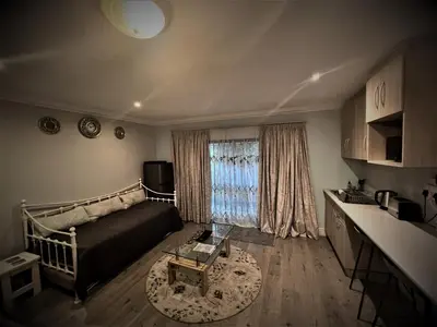 a living room with a bed and a window at Ridgeworth, Tygervalley in Cape Town