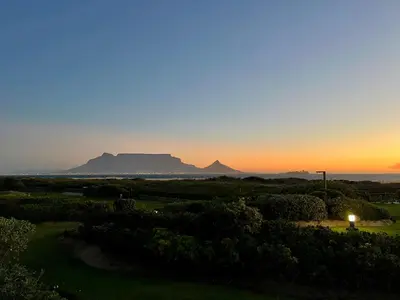 a sunset with table mountain in the background at Dolphin Beach Cabana in Table View