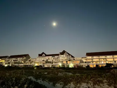 a large building with the moon in the sky at Dolphin Beach Cabana in Table View