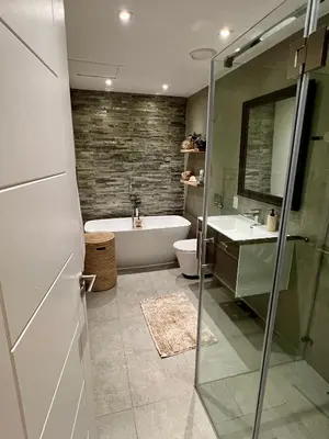 a bathroom with a tub and a toilet and a sink at Dolphin Beach Cabana in Table View